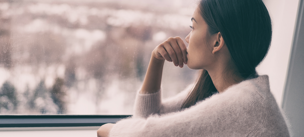 dark haired woman staring out window